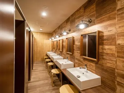 a row of sinks in a bathroom with wooden walls at eeGee STAY Kamata