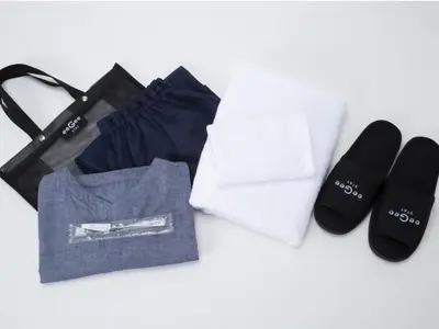 a pile of clothes and a bag and a pair of slippers at eeGee STAY Kamata