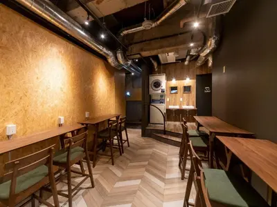 a dining room with wooden tables and chairs at eeGee STAY Kamata