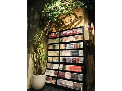 a book shelf filled with books next to a wall at eeGee STAY Kamata