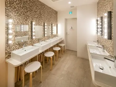 a bathroom with a row of sinks and mirrors at eeGee STAY Kamata