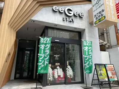 a store with green signs in front of a building at eeGee STAY Kamata