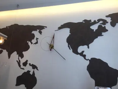a black world clock on a white wall at eeGee STAY Kamata