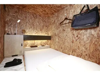 a bedroom with a bed and a tv on the wall at eeGee STAY Kamata