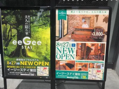 two posters for a new open sign in a store at eeGee STAY Kamata
