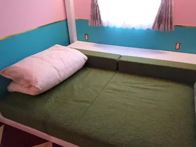 a bed in a small room with a pink pillow at FourStoriesHotelMaihama Tokyo Bay - Vacation STAY 73130v in Tokyo
