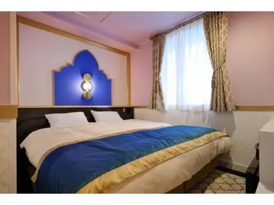 a bedroom with a bed with a blue headboard and a window at FourStoriesHotelMaihama Tokyo Bay - Vacation STAY 73113v in Tokyo