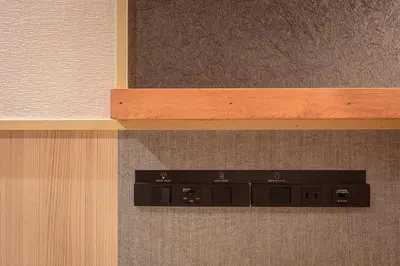 a black object on a wall with a wooden shelf at ENSO TOKYO Akasaka in Tokyo
