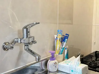 a sink with a faucet and toothbrushes and toothpaste at TD Link Ooyama Cozy Escape Sleeps 8 Direct to Ikebukuro in Tokyo