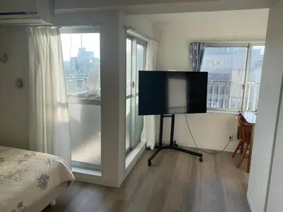 a bedroom with a flat screen tv in front of a window at Cozy corner in Tokyo