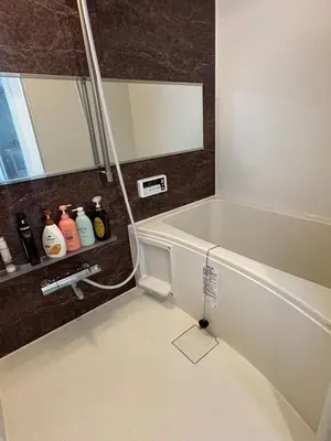 a bathroom with a bath tub and a mirror at Cozy corner in Tokyo