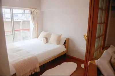 a bedroom with a white bed with a window at Shibuya-E604 in Tokyo