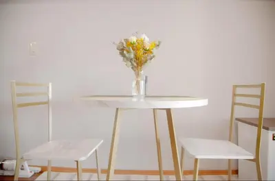 a vase of flowers sitting on a table with two chairs at Shibuya-E604 in Tokyo