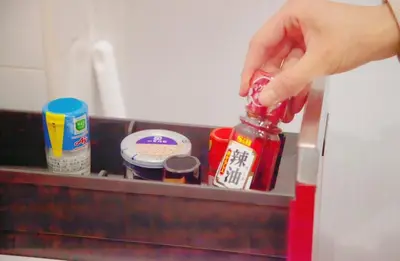 a person is holding a jar of ketchup at Shibuya-E604 in Tokyo