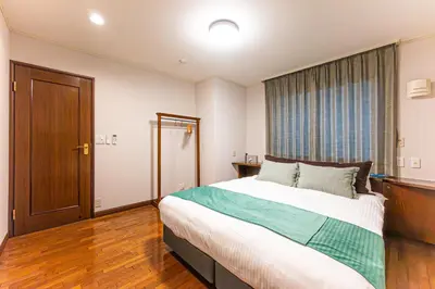 a bedroom with a large bed and a large window at Poka Villa Aoyama in Tokyo