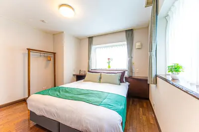 a bedroom with a large bed and a window at Poka Villa Aoyama in Tokyo