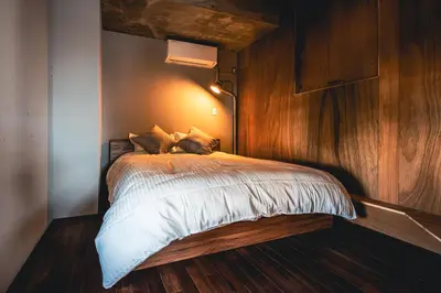 a bedroom with a bed with a wooden wall at Rimba Tokyo Oshiage, Skytree view, 3BR 80m2 in Tokyo