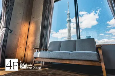 a couch in a room with a view of the tokyo tower at Rimba Tokyo Oshiage, Skytree view, 3BR 80m2 in Tokyo