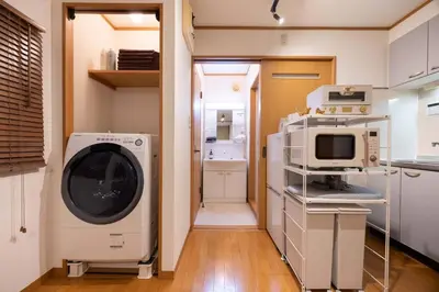 a laundry room with a washer and a microwave at House Hotel Kagurazaka HHK1 in Tokyo