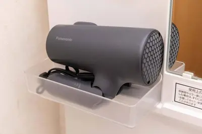 a black speaker in a holder on a wall at House Hotel Kagurazaka HHK1 in Tokyo