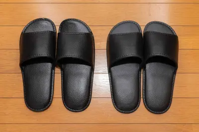 four pairs of black shoes on a wooden floor at House Hotel Kagurazaka HHK1 in Tokyo