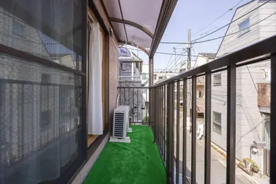 a balcony with a green floor in a building at House Hotel Kagurazaka HHK1 in Tokyo