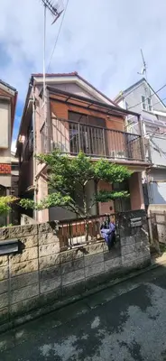 a person sitting on the porch of a house at House Hotel Kagurazaka HHK1 in Tokyo