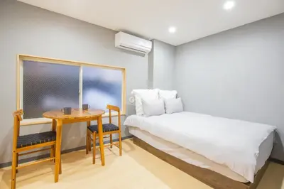 a bedroom with a bed and a desk and a table at \u8535\u524d\u99c5\u5f92\u6b693\u5206 \u6771\u4eac\u30b9\u30ab\u30a4\u30c4\u30ea\u30fc\u773a\u671b\u306e\u5feb\u9069\u5bbf YoEL in Tokyo