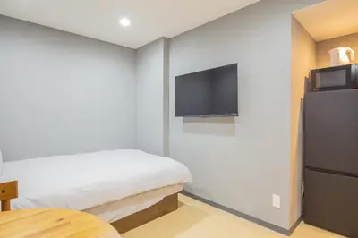 a bedroom with a bed and a tv on the wall at \u8535\u524d\u99c5\u5f92\u6b693\u5206 \u6771\u4eac\u30b9\u30ab\u30a4\u30c4\u30ea\u30fc\u773a\u671b\u306e\u5feb\u9069\u5bbf YoEL in Tokyo