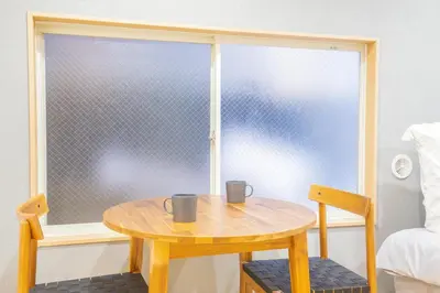 a table with two mugs on it in front of a window at \u8535\u524d\u99c5\u5f92\u6b693\u5206 \u6771\u4eac\u30b9\u30ab\u30a4\u30c4\u30ea\u30fc\u773a\u671b\u306e\u5feb\u9069\u5bbf YoEL in Tokyo