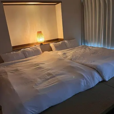 two beds sitting next to each other in a hotel room at Ninja House in Tokyo