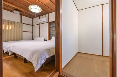 a bedroom with a bed and a mirror at Momiji Hotel in Tokyo