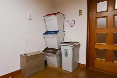 a room with two trash cans and a door at Momiji Hotel in Tokyo