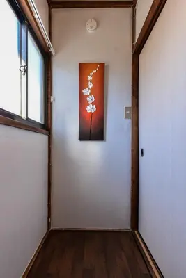a hallway with a painting on the wall and a door at \u693f Tubaki in Tokyo