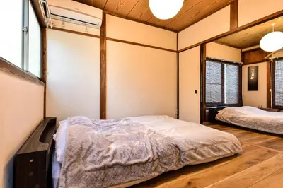 two beds in a room with wooden floors and windows at \u693f Tubaki in Tokyo