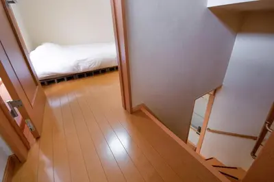 a hallway leading to a bedroom with a bed at Yellow House in Tokyo
