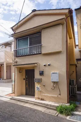 a building with a balcony on the side of it at Yellow House in Tokyo