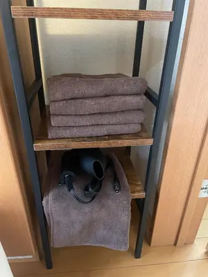 a group of towels on a shelf in a room at Yellow House in Tokyo