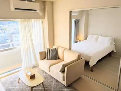 a bedroom with a bed and a couch and a mirror at Ebisu Top floor 1BR Condo with Mount Fuji view in Tokyo