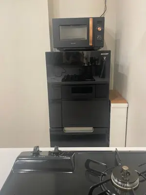 a kitchen with a stove with a microwave and a television at Ebisu Top floor 1BR Condo with Mount Fuji view in Tokyo