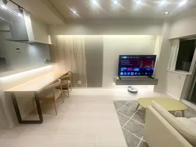 a living room with a flat screen tv on a wall at Ebisu Top floor 1BR Condo with Mount Fuji view in Tokyo