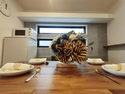 a dining room table with a vase of flowers on it at C1 Shibuya new hotel, 2 bedrooms and 1 living room, 7 mins to ST Max 6P \u6e0b\u8c37\u5168\u65b0\u9152\u5e97 \u5168\u65b0\u88c5\u4fee \u4e24\u5ba4\u4e00\u5385 \u4ea4\u901a\u4e2d\u5fc3 \u8f66\u7ad97\u5206\u949f \u6700\u59276\u4eba \u76f4\u8fbe\u65b0\u5bbf \u6d89\u8c37 \u8868\u53c2\u9053 \u54c1\u5ddd \u6c60\u888b \u4e0a\u91ce \u4ee3\u4ee3\u6728 \u94f6\u5ea7 \u539f\u5bbf in Tokyo