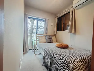 a bedroom with a bed with a pillow on it at C1 Shibuya new hotel, 2 bedrooms and 1 living room, 7 mins to ST Max 6P \u6e0b\u8c37\u5168\u65b0\u9152\u5e97 \u5168\u65b0\u88c5\u4fee \u4e24\u5ba4\u4e00\u5385 \u4ea4\u901a\u4e2d\u5fc3 \u8f66\u7ad97\u5206\u949f \u6700\u59276\u4eba \u76f4\u8fbe\u65b0\u5bbf \u6d89\u8c37 \u8868\u53c2\u9053 \u54c1\u5ddd \u6c60\u888b \u4e0a\u91ce \u4ee3\u4ee3\u6728 \u94f6\u5ea7 \u539f\u5bbf in Tokyo