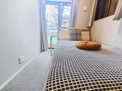 a bed in a room with a large window at C2 Shibuya new hotel, 2 bedrooms and 1 living room, 7 mins to ST Max 6P \u6e0b\u8c37\u5168\u65b0\u9152\u5e97 \u5168\u65b0\u88c5\u4fee \u4e24\u5ba4\u4e00\u5385 \u4ea4\u901a\u4e2d\u5fc3 \u8f66\u7ad97\u5206\u949f \u6700\u59276\u4eba \u76f4\u8fbe\u65b0\u5bbf \u6d89\u8c37 \u8868\u53c2\u9053 \u54c1\u5ddd \u6c60\u888b \u4e0a\u91ce \u4ee3\u4ee3\u6728 \u94f6\u5ea7 \u539f\u5bbf in Tokyo