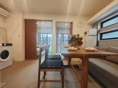 a kitchen and living room with a table and a couch at C2 Shibuya new hotel, 2 bedrooms and 1 living room, 7 mins to ST Max 6P \u6e0b\u8c37\u5168\u65b0\u9152\u5e97 \u5168\u65b0\u88c5\u4fee \u4e24\u5ba4\u4e00\u5385 \u4ea4\u901a\u4e2d\u5fc3 \u8f66\u7ad97\u5206\u949f \u6700\u59276\u4eba \u76f4\u8fbe\u65b0\u5bbf \u6d89\u8c37 \u8868\u53c2\u9053 \u54c1\u5ddd \u6c60\u888b \u4e0a\u91ce \u4ee3\u4ee3\u6728 \u94f6\u5ea7 \u539f\u5bbf in Tokyo