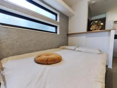 a large bed in a bedroom with a large window at C2 Shibuya new hotel, 2 bedrooms and 1 living room, 7 mins to ST Max 6P \u6e0b\u8c37\u5168\u65b0\u9152\u5e97 \u5168\u65b0\u88c5\u4fee \u4e24\u5ba4\u4e00\u5385 \u4ea4\u901a\u4e2d\u5fc3 \u8f66\u7ad97\u5206\u949f \u6700\u59276\u4eba \u76f4\u8fbe\u65b0\u5bbf \u6d89\u8c37 \u8868\u53c2\u9053 \u54c1\u5ddd \u6c60\u888b \u4e0a\u91ce \u4ee3\u4ee3\u6728 \u94f6\u5ea7 \u539f\u5bbf in Tokyo