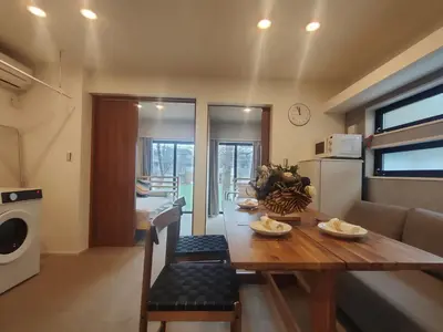 a kitchen and living room with a table and a couch at C3 Shibuya new hotel, 2 bedrooms and 1 living room, 7 mins to ST Max 6P \u6e0b\u8c37\u5168\u65b0\u9152\u5e97 \u5168\u65b0\u88c5\u4fee \u4e24\u5ba4\u4e00\u5385 \u4ea4\u901a\u4e2d\u5fc3 \u8f66\u7ad97\u5206\u949f \u6700\u59276\u4eba \u76f4\u8fbe\u65b0\u5bbf \u6d89\u8c37 \u8868\u53c2\u9053 \u54c1\u5ddd \u6c60\u888b \u4e0a\u91ce \u4ee3\u4ee3\u6728 \u94f6\u5ea7 \u539f\u5bbf in Tokyo