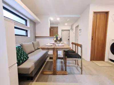a living room with a table and a couch at C3 Shibuya new hotel, 2 bedrooms and 1 living room, 7 mins to ST Max 6P \u6e0b\u8c37\u5168\u65b0\u9152\u5e97 \u5168\u65b0\u88c5\u4fee \u4e24\u5ba4\u4e00\u5385 \u4ea4\u901a\u4e2d\u5fc3 \u8f66\u7ad97\u5206\u949f \u6700\u59276\u4eba \u76f4\u8fbe\u65b0\u5bbf \u6d89\u8c37 \u8868\u53c2\u9053 \u54c1\u5ddd \u6c60\u888b \u4e0a\u91ce \u4ee3\u4ee3\u6728 \u94f6\u5ea7 \u539f\u5bbf in Tokyo
