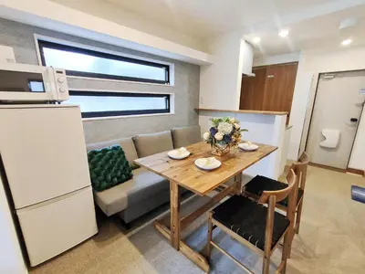 a kitchen and dining room with a table and a couch at C3 Shibuya new hotel, 2 bedrooms and 1 living room, 7 mins to ST Max 6P \u6e0b\u8c37\u5168\u65b0\u9152\u5e97 \u5168\u65b0\u88c5\u4fee \u4e24\u5ba4\u4e00\u5385 \u4ea4\u901a\u4e2d\u5fc3 \u8f66\u7ad97\u5206\u949f \u6700\u59276\u4eba \u76f4\u8fbe\u65b0\u5bbf \u6d89\u8c37 \u8868\u53c2\u9053 \u54c1\u5ddd \u6c60\u888b \u4e0a\u91ce \u4ee3\u4ee3\u6728 \u94f6\u5ea7 \u539f\u5bbf in Tokyo