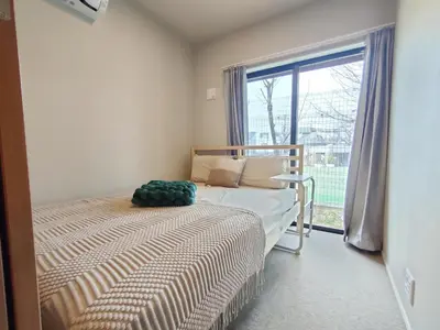 a bedroom with a bed and a large window at C3 Shibuya new hotel, 2 bedrooms and 1 living room, 7 mins to ST Max 6P \u6e0b\u8c37\u5168\u65b0\u9152\u5e97 \u5168\u65b0\u88c5\u4fee \u4e24\u5ba4\u4e00\u5385 \u4ea4\u901a\u4e2d\u5fc3 \u8f66\u7ad97\u5206\u949f \u6700\u59276\u4eba \u76f4\u8fbe\u65b0\u5bbf \u6d89\u8c37 \u8868\u53c2\u9053 \u54c1\u5ddd \u6c60\u888b \u4e0a\u91ce \u4ee3\u4ee3\u6728 \u94f6\u5ea7 \u539f\u5bbf in Tokyo